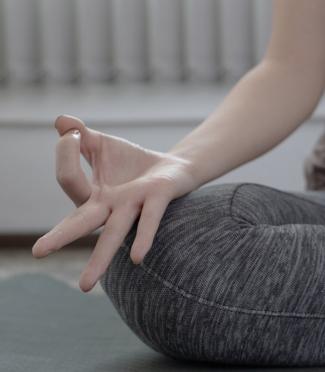 Eine Person macht Yoga im Schneidersitz.