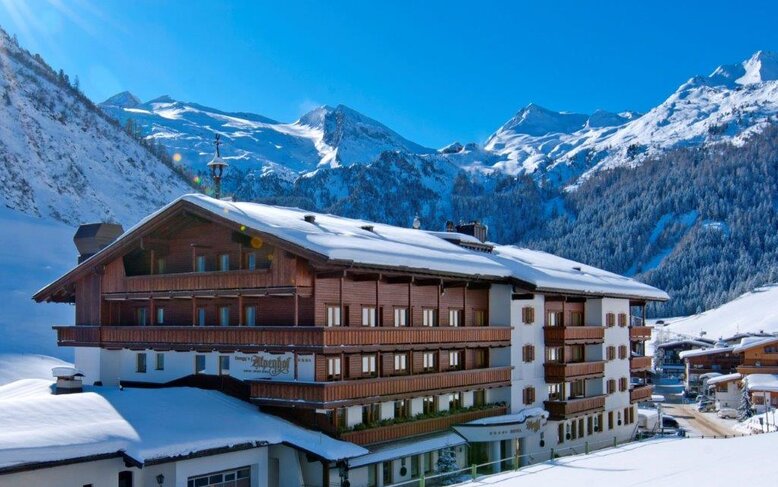 Ein wunderschönes Winterpanorama mit dem Alpenhof-Hotel, das sich harmonisch in die schneebedeckte Berglandschaft einfügt.